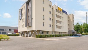 A hotel with a modern design, featuring multiple floors and balconies. - ACE Hôtel Paris Roissy (Mitry-Mory)