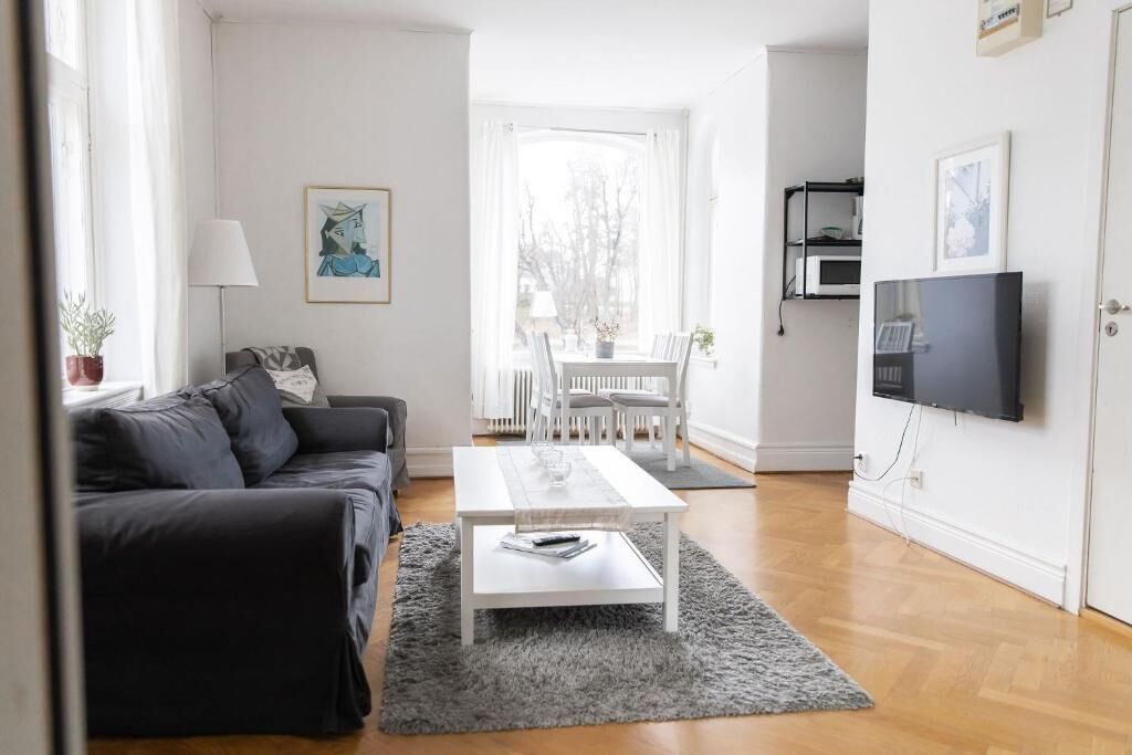 Ein modernes Wohnzimmer mit einer Couch, einem Couchtisch und einem Essbereich mit Stühlen.