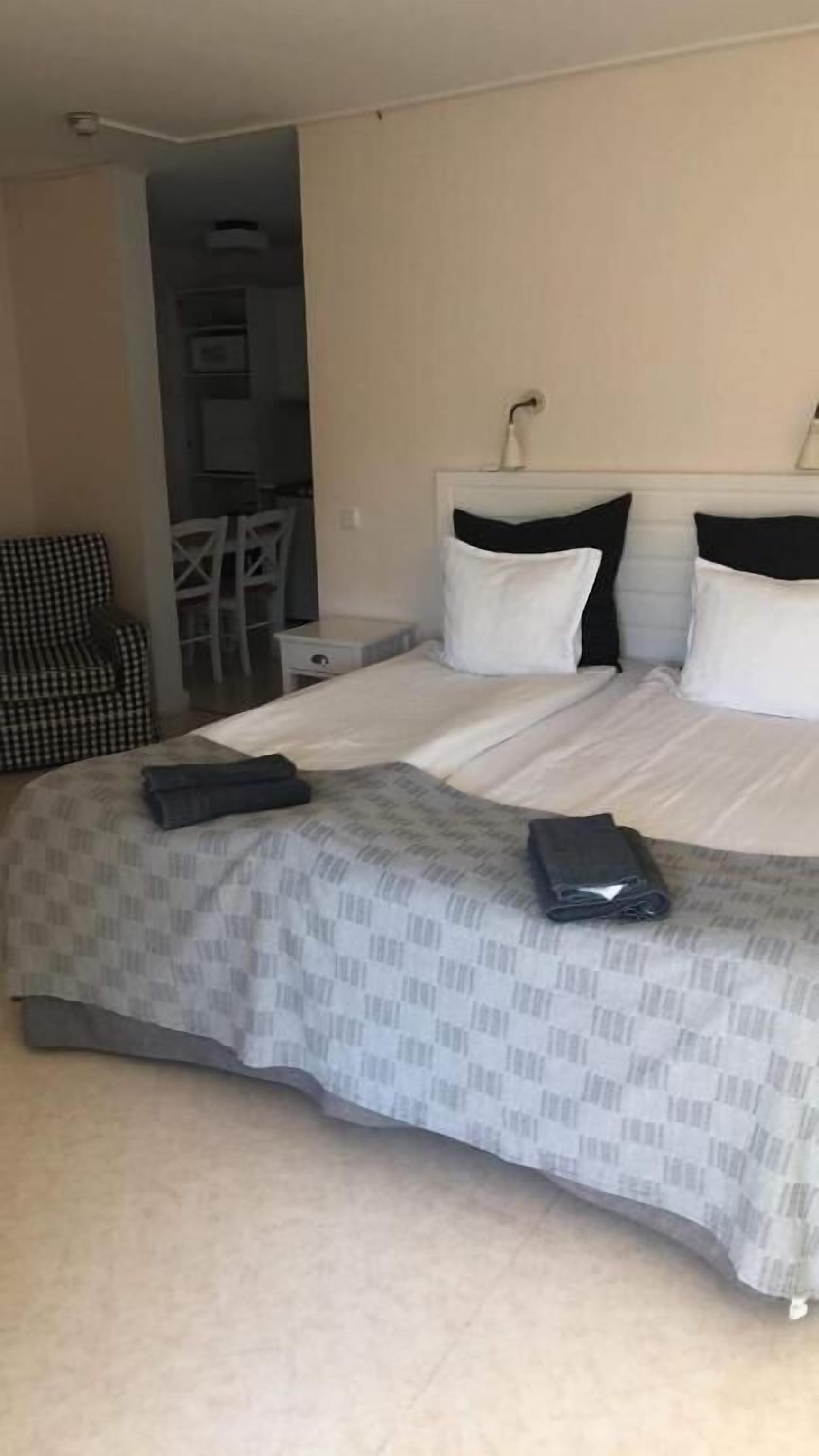 Una habitación de hotel con una cama, un escritorio y una silla.