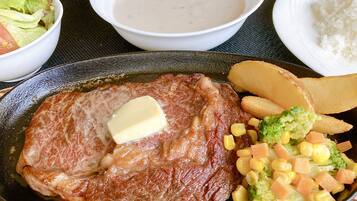Een bord met steak, boter en groenten.