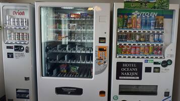 Tres máquinas expendedoras con diferentes bebidas y aperitivos.
