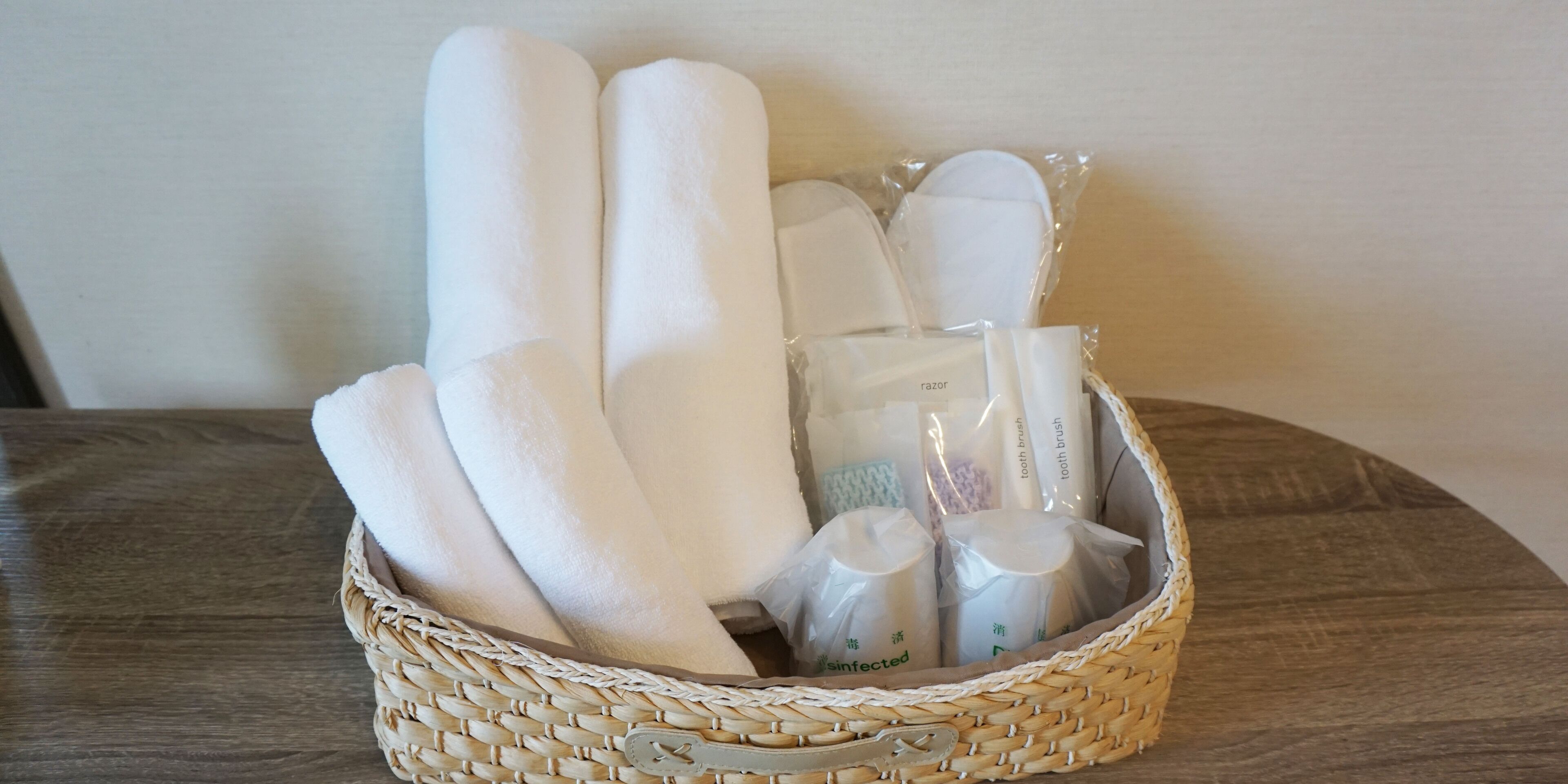 A woven basket containing various toiletries including toothbrushes and a razor.