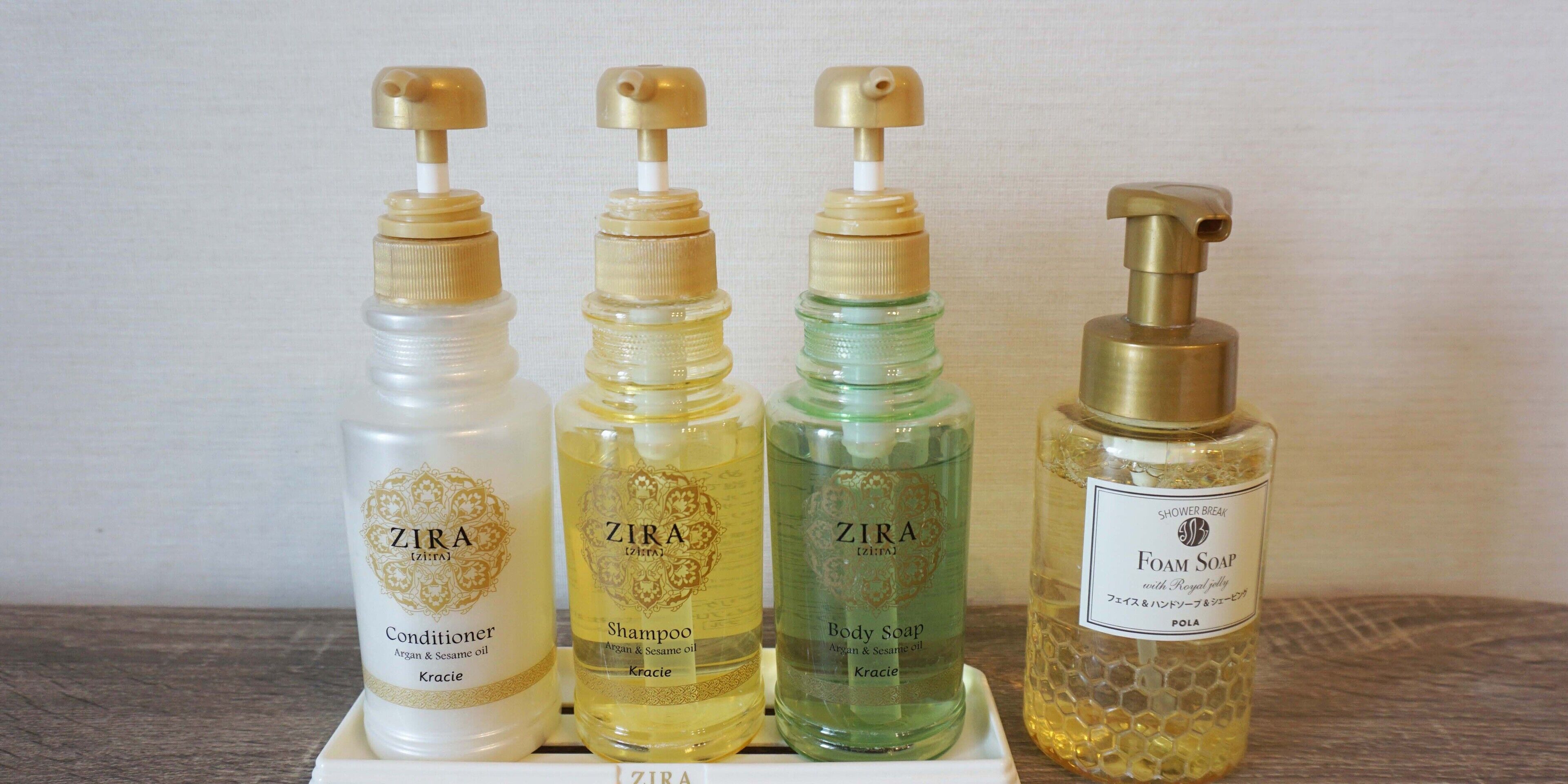 Four bottles of ZIRA products: conditioner, shampoo, body soap, and foam soap.