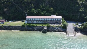 A large building with multiple balconies, situated by a clear waterfront. - Hotel Oceans Nakijin (Nakijin)
