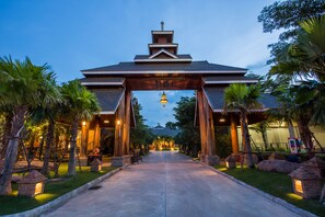 A hotel entrance with a traditional architectural style, featuring a central archway and a bell above it.