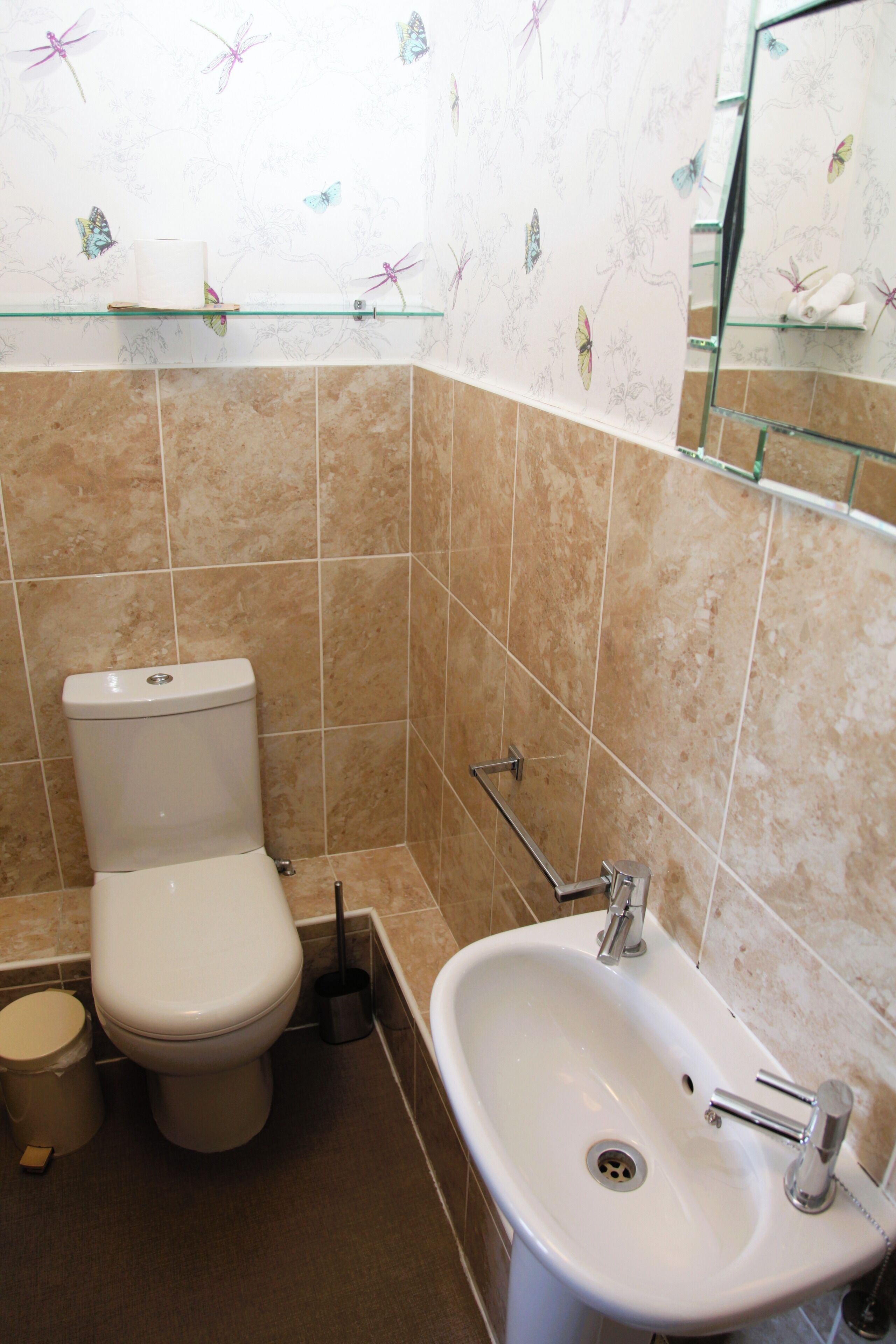 Ein Badezimmer mit Toilette, Waschbecken und Ablage über dem Waschbecken.