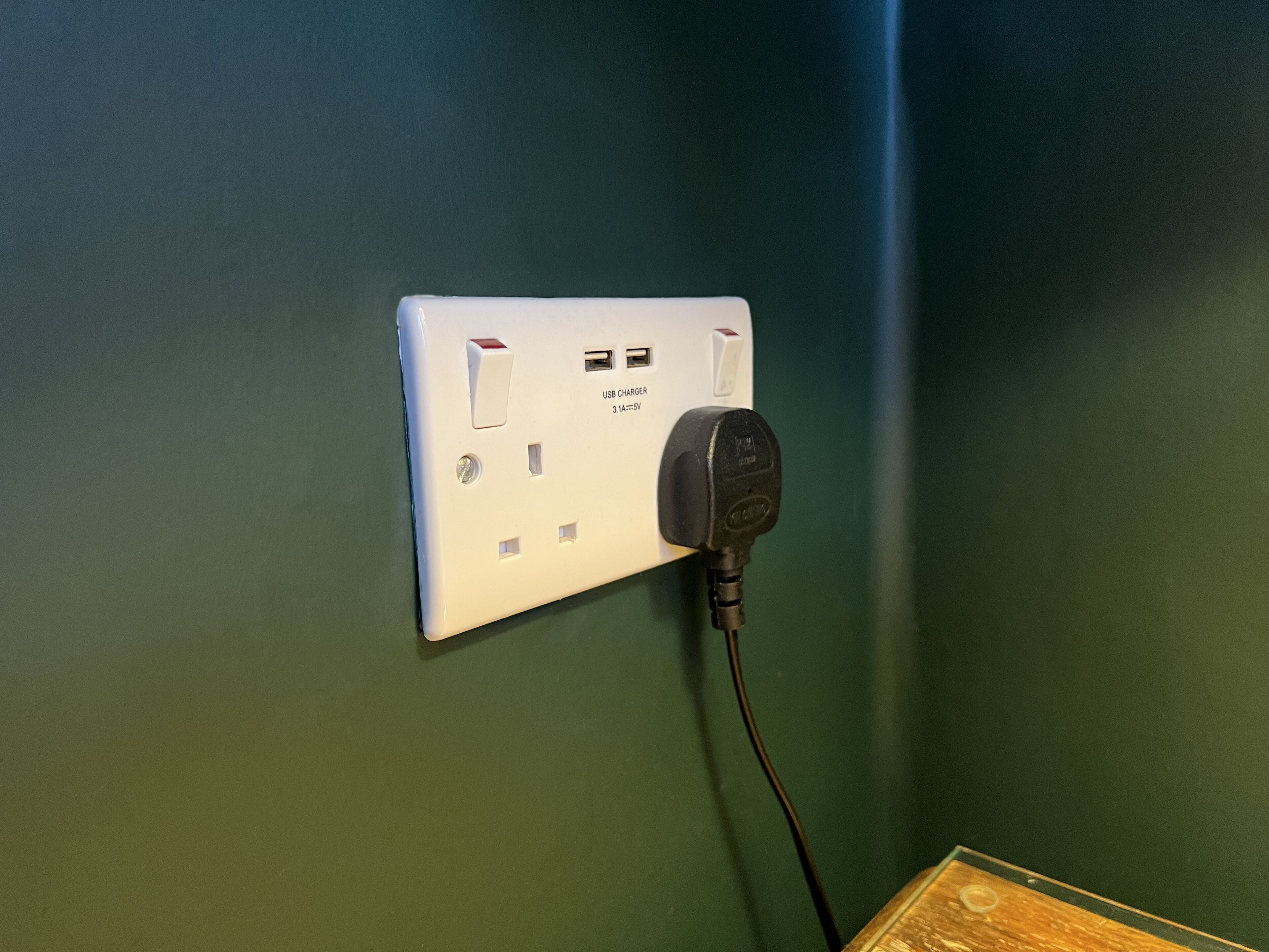 Een wandcontactdoos met USB-lader en een stroomkabel.