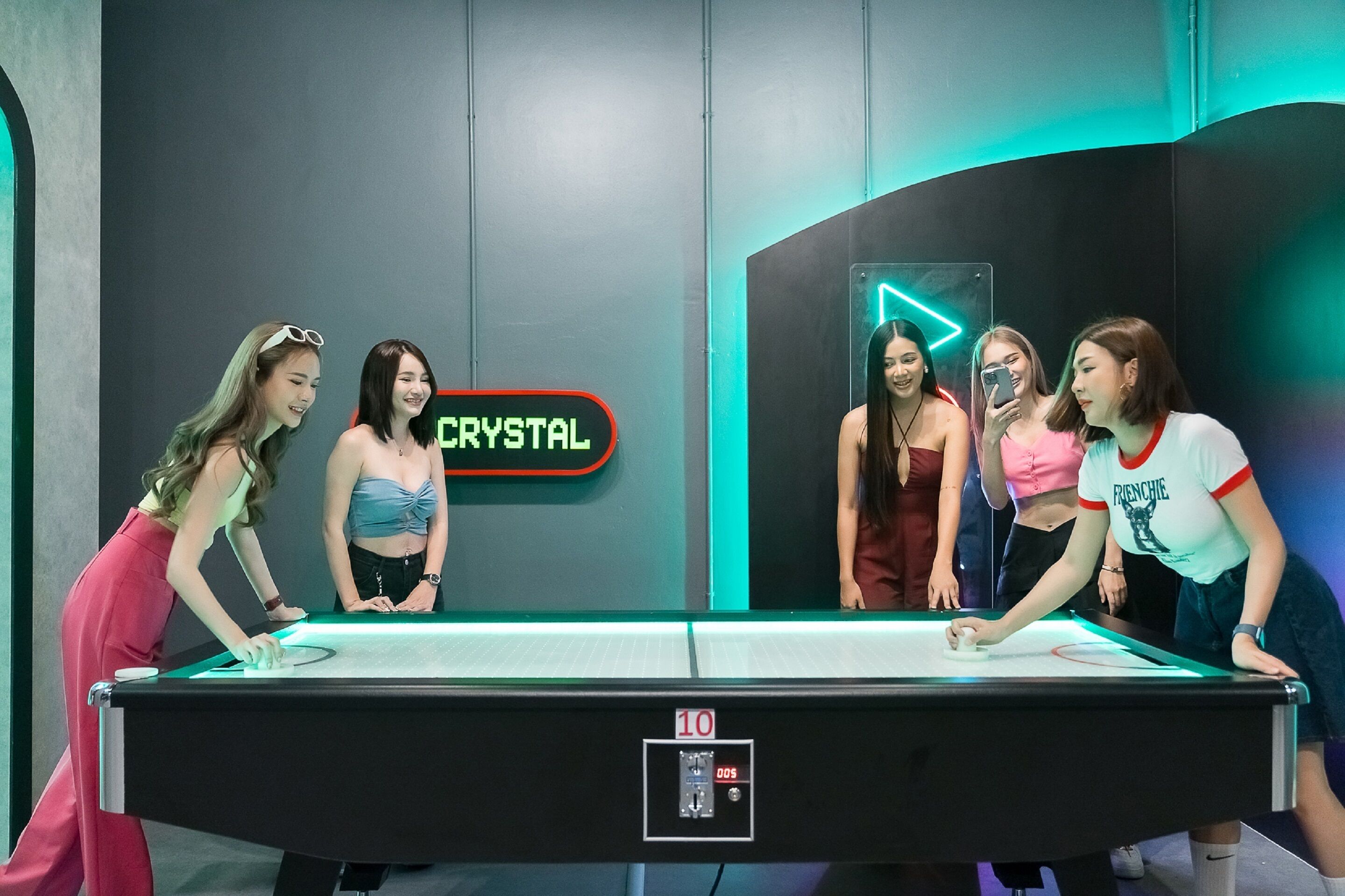 A pool table in a room with a neon sign reading "CRYSTAL" and a digital clock displaying "10:00".