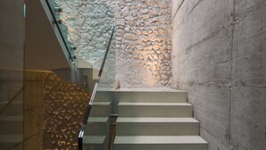A staircase with a glass railing and a stone wall. - Locanda al Vescovo (Verona)