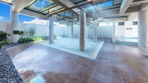 A modern indoor water feature with a central column and multiple water jets, surrounded by a tiled floor and a clear sky visible through the ceiling. - Formosa Naruwan Galaxy Hotel Taitung (Taitung)