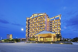 A multi-story hotel with a modern design, featuring a covered entrance and a parking area in front. - Formosa Naruwan Galaxy Hotel Taitung (Taitung)