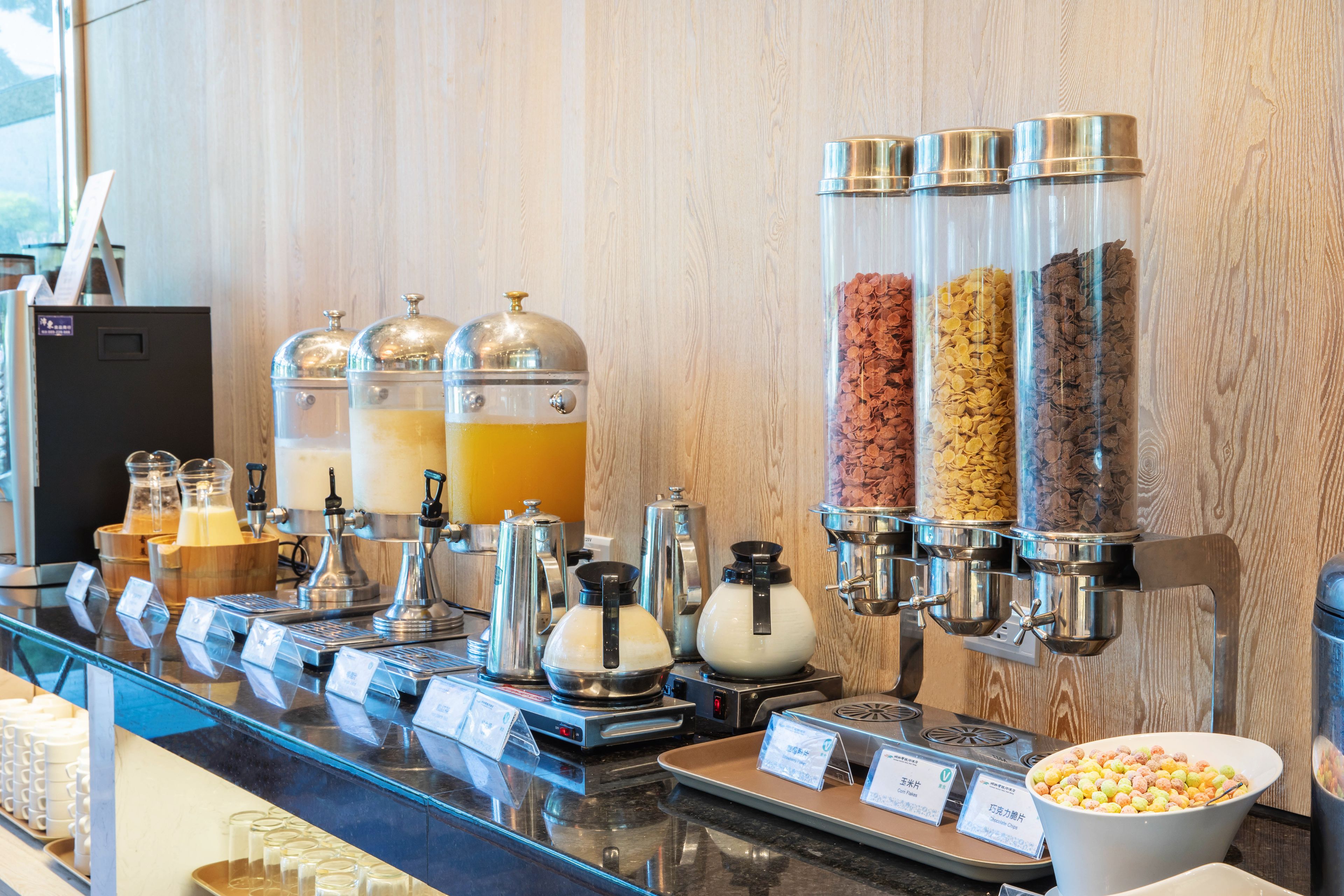 A breakfast bar with various food dispensers, including cereal and coffee options.