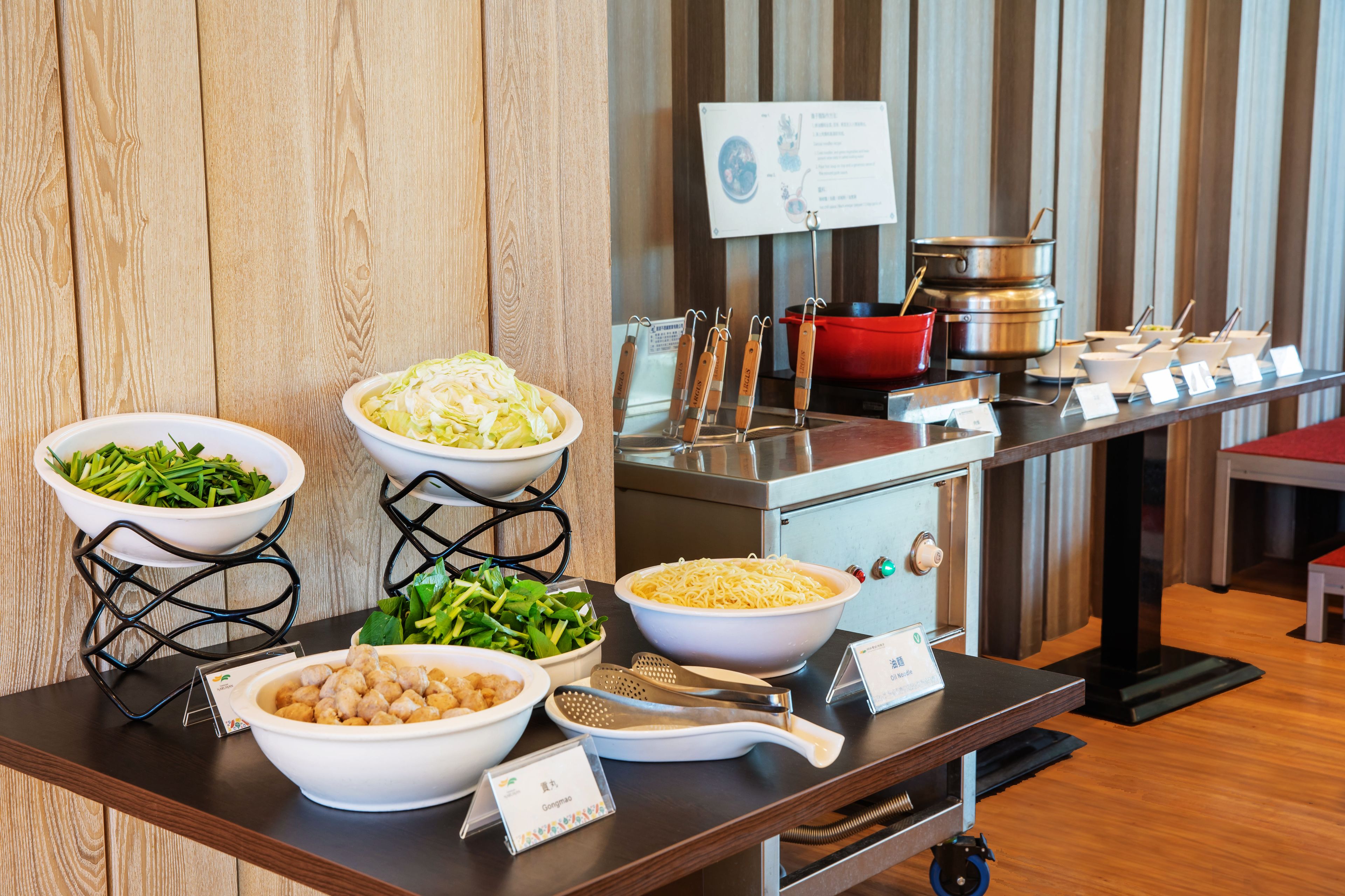 A buffet setup with various dishes and utensils.