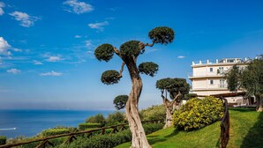 A coastal landscape with a tree, a building, and a view of the sea. - Villa Fiorella Art Hotel (Massa Lubrense)