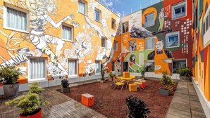 A courtyard with colorful murals, outdoor seating, and potted plants. - B&B HOME Paris Mairie de Saint-Ouen (Saint-Ouen)