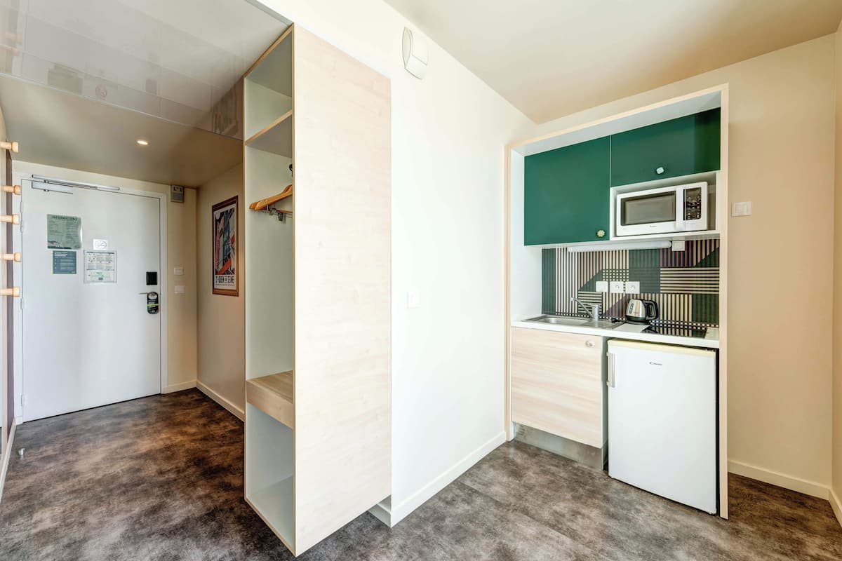 A compact kitchen with a microwave, coffee maker, and a small refrigerator.