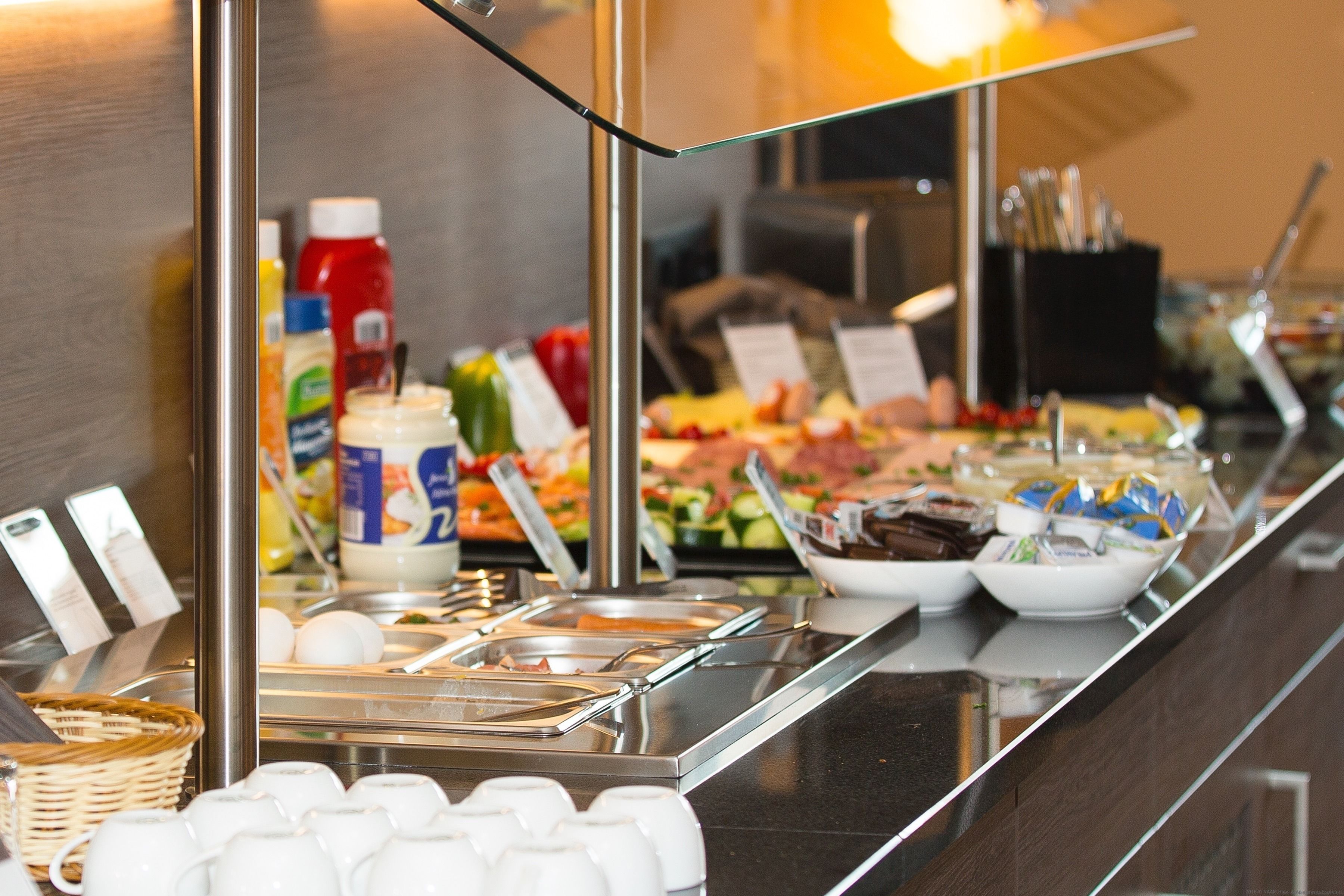 Un buffet con diversi piatti, condimenti e utensili.