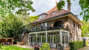 A two-story building with a brick facade, large windows, and a balcony. - Boutique Hotel Het Scheepshuys (Breda)
