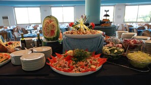 Une table de buffet garnie de divers plats et agrémentée d’un centre de table décoratif.