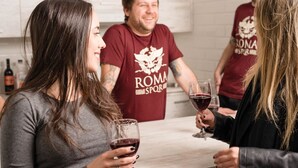 A group of people in a kitchen with a countertop, wine glasses, and a bottle of wine. - Hostel Beautiful (Rome)