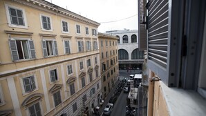 A street view with a row of parked cars and a building with a sign that reads "HOTEL." - Hostel Beautiful (Rome)
