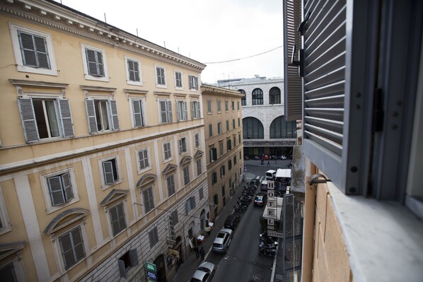 A street view with a row of parked cars and a building with a sign that reads "HOTEL." - Hostel Beautiful (Rome)