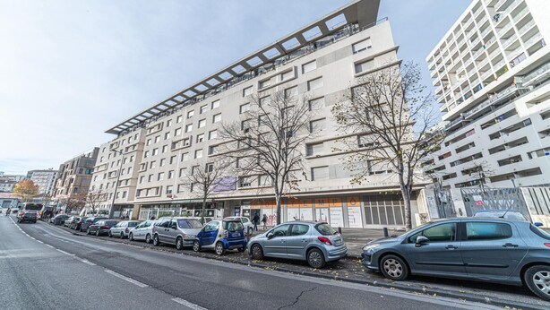 Un edificio a più piani dal design architettonico moderno, caratterizzato da un tetto piatto e ampie finestre.