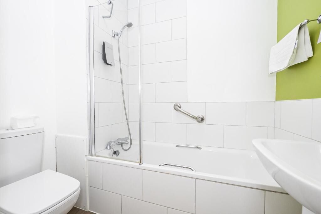 Une salle de bain avec des toilettes, une douche et une baignoire.