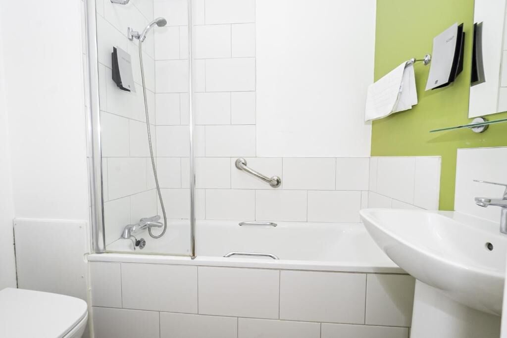 A bathroom with a shower, a bathtub, and a sink.