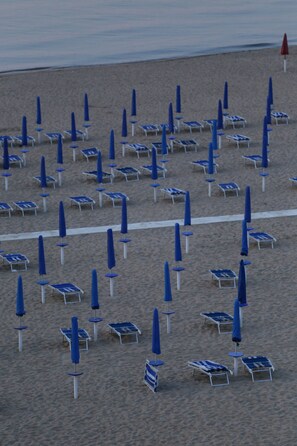 On the beach, white sand, sun-loungers, beach umbrellas