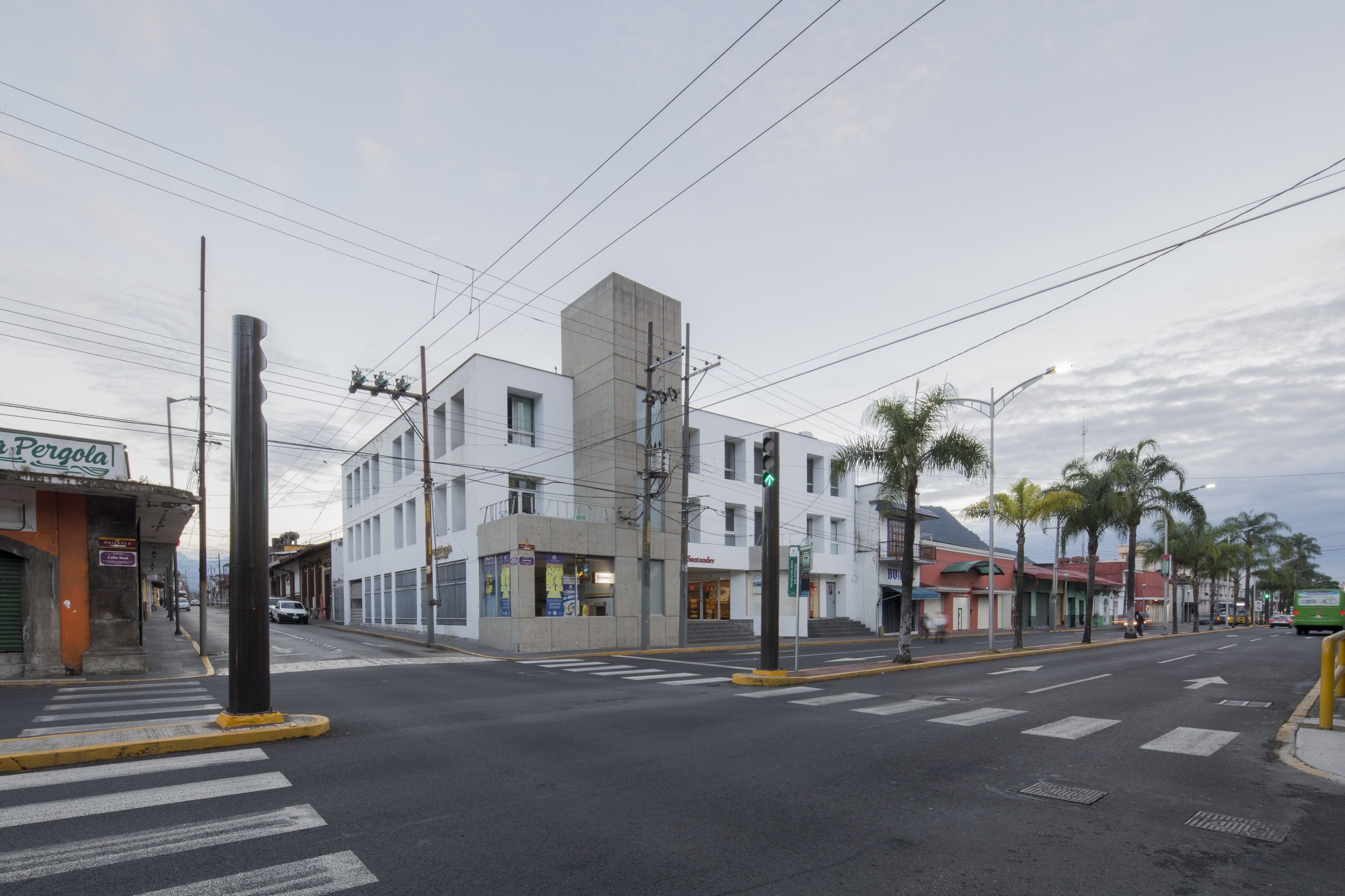 Vista de una calle con edificios, un paso de peatones y un semáforo en verde.