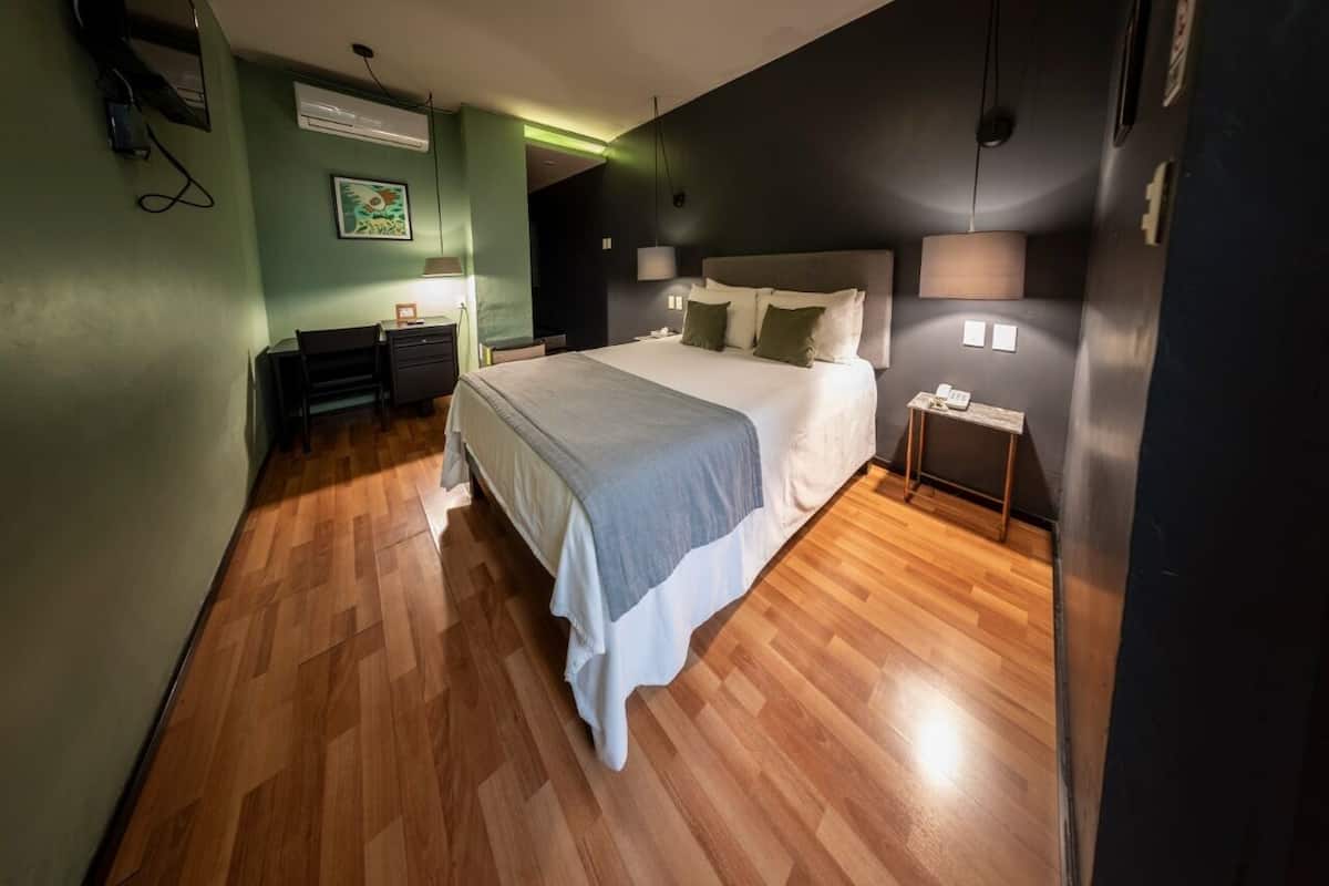 Een moderne slaapkamer met een groot bed, een bureau en een stoel.