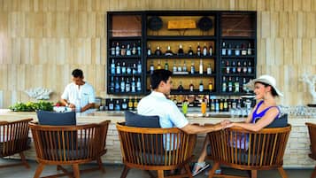 Un espace bar avec des chaises en bois et un barman.