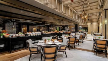 A spacious restaurant with high ceilings, modern lighting, and a variety of seating arrangements.