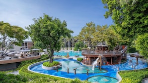 Een resort met een groot zwembad, diverse waterattracties en terras zitplaatsen.