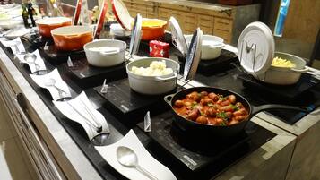 A buffet setup with various food items and utensils.