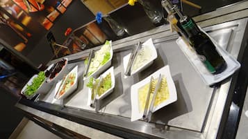 Un mostrador de buffet con diversos alimentos y utensilios.