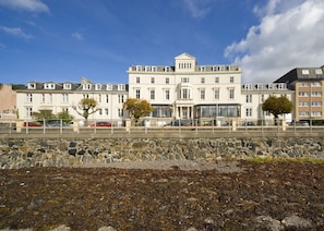 A large, multi-story building with a symmetrical facade, large windows, and a central entrance.