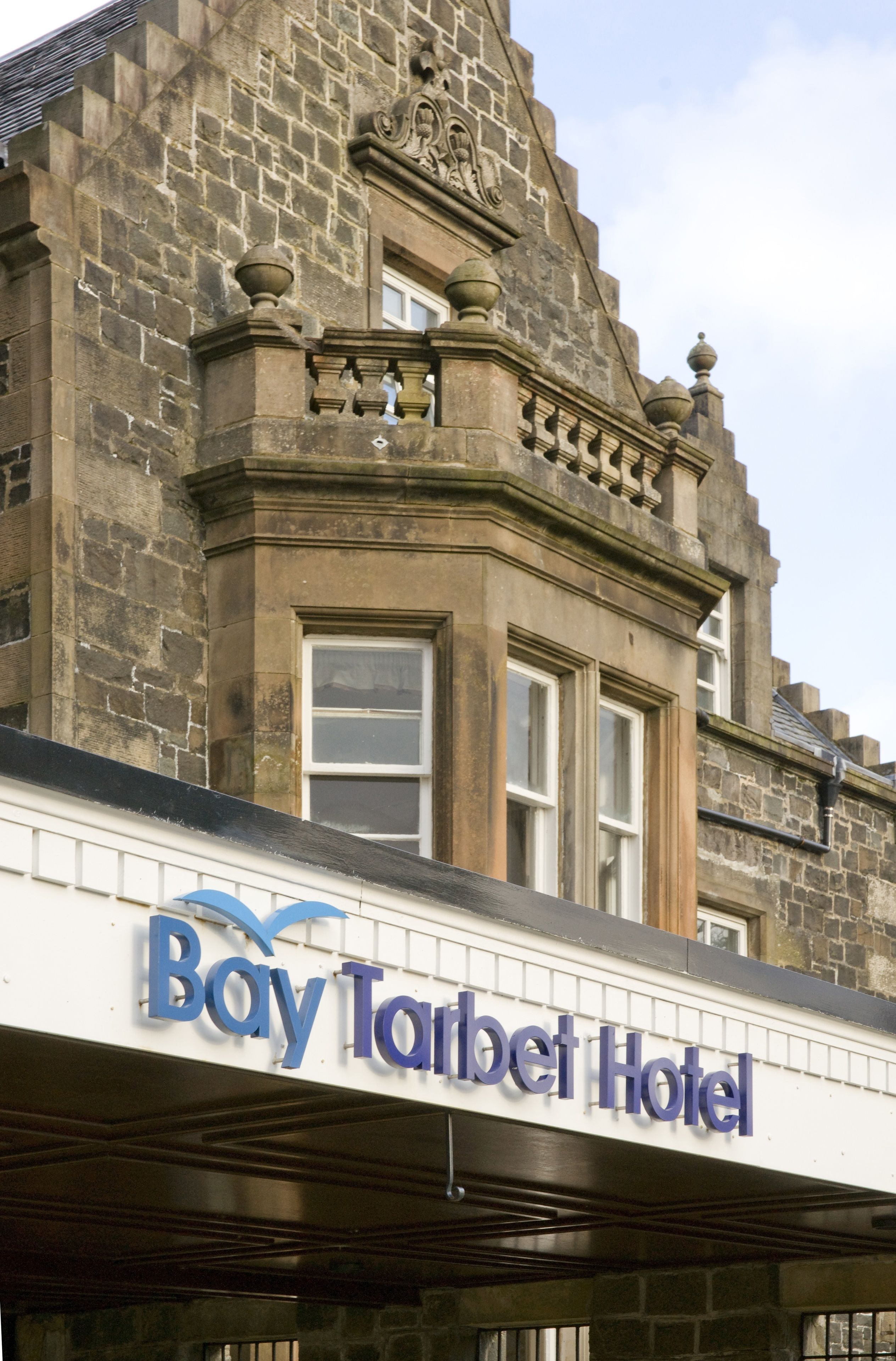 Exterior del Hotel Bay Tarbert, con arquitectura de piedra y una entrada destacada.