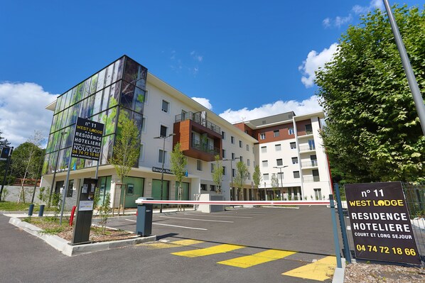 Un edificio moderno con un cartel que indica West Lodge Residence Hotel.