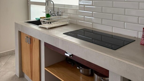A modern kitchen with a built-in stove, a window above the sink, and a white tiled backsplash. - Privada 400 Casas & Suites (Pachuca)
