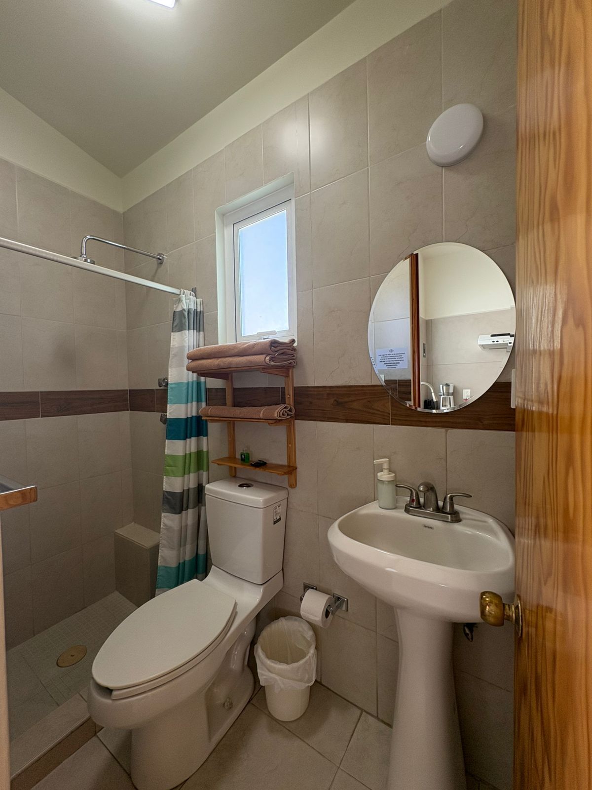 Une petite salle de bain comprenant des toilettes, un lavabo et un espace douche.