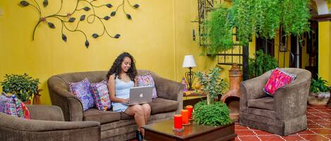 A cozy indoor setting with a yellow wall, a brown sofa, and a coffee table with candles.
