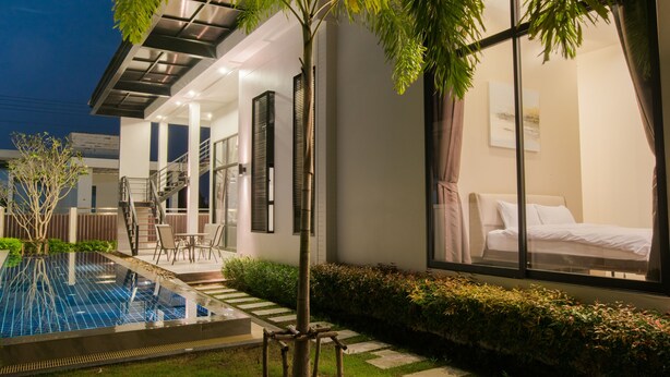 Un hôtel moderne doté d’une piscine, d’un escalier menant à l’étage supérieur et d’un jardin bien entretenu.