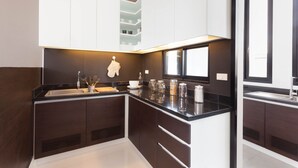 Une cuisine moderne avec des meubles en bois foncé, un plan de travail noir et une fenêtre au-dessus de l’évier.