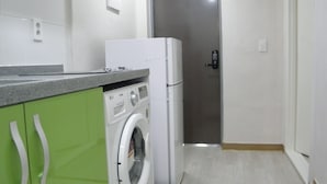 A compact kitchen with a washing machine, a refrigerator, and a microwave. - Good Morning Vil Residenece Inn (Gumi)