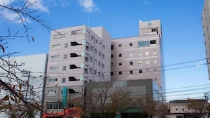 Un edificio de varios pisos con fachada plana, varias ventanas y una señal visible en la parte superior.