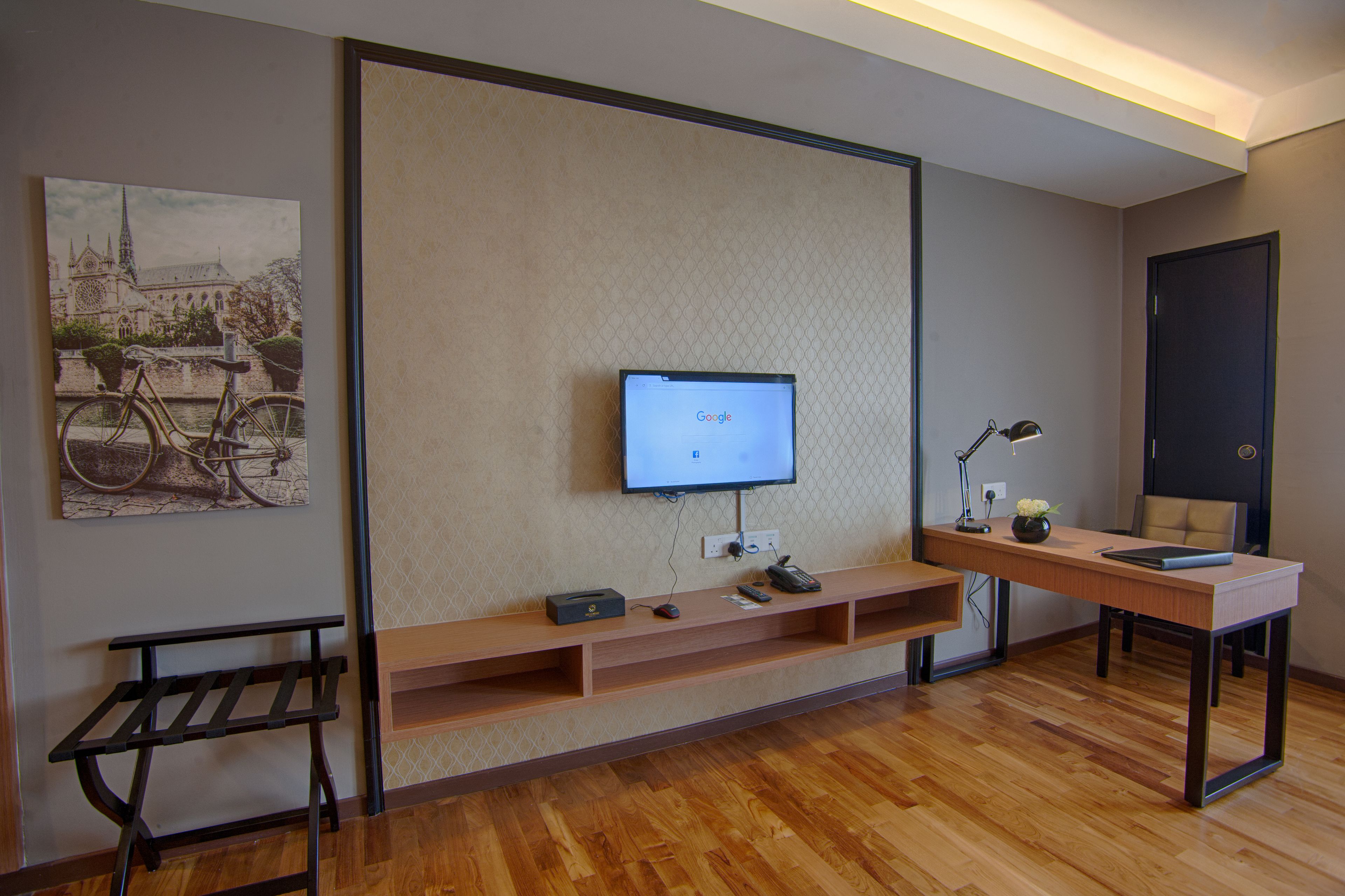 A modern room with a wooden desk, a mounted TV, and a bench.