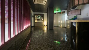 A corridor with a patterned floor, a reception area, and a staircase. - Hotel Wacha Wacha - Adults Only (Kyoto)