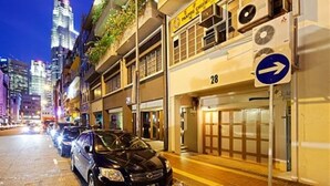Un carrer de ciutat de nit, amb cotxes aparcats i edificis.